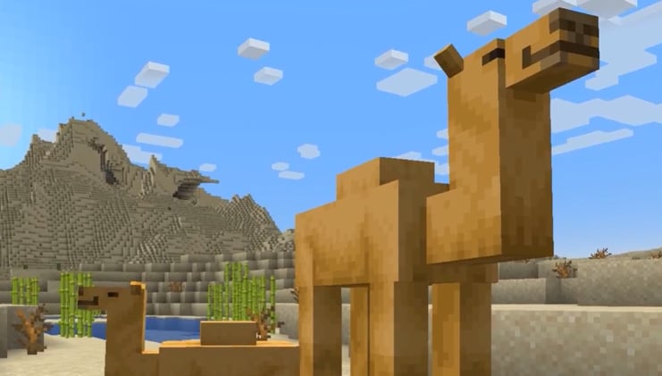 Image of Minecraft camels surrounded by sand blocks and some sand mounds in the background.