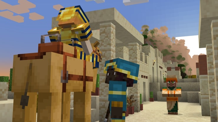 A player in blue leather armor trimmed with gold greets a player in gold armor trimmed with lapis riding a camel. In the background, a villager watches.