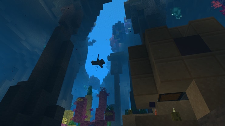 Looking up at the silhouette of a player swimming down an ocean ravine to an ocean ruin.