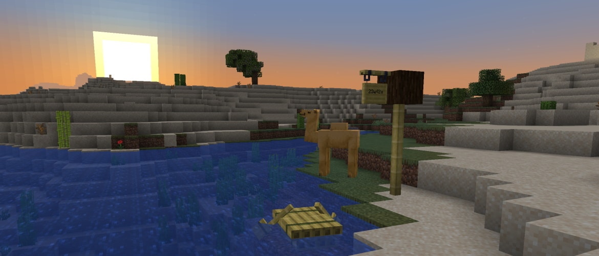 A camel is standing next to a river looking at the sun setting behind a dune. In front of the camel, there's a post made out of bamboo blocks with a hanging sign on it that says "22w42a".